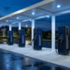 Unbranded DC fast chargers under a lit canopy at dusk, illustrating what the carbon credit trading scheme is worth to an EV charging operator