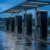 NIS2 and EV charging compliance: a row of DC fast chargers at a European roadside charging hub at dusk